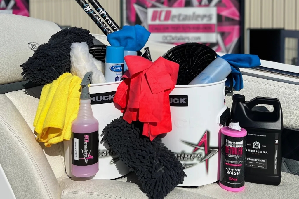 A complete marine detailing kit from OCDetailers sits on a boat seat in Osage Beach, featuring microfiber towels, soaps, brushes, a wash bucket, and ceramic aftercare products. This setup supports The Role of PPF by promoting proper maintenance for long-lasting hull protection.
